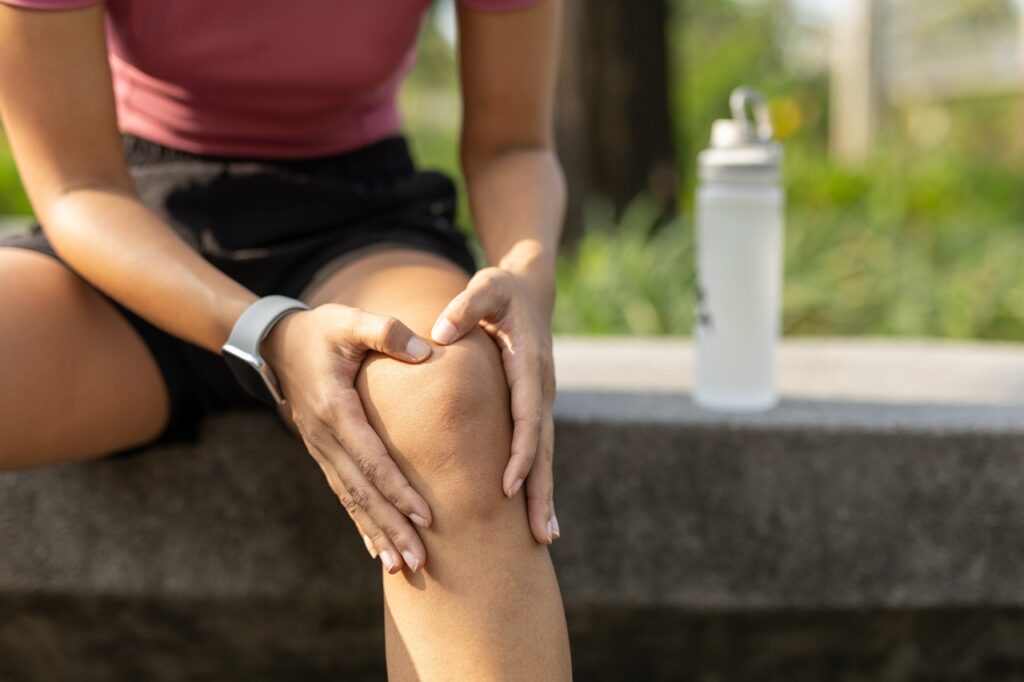 Kobieta trzymająca się na nogę na murku w Warszawie