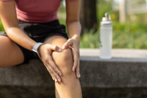 Kobieta trzymająca się na nogę na murku w Warszawie